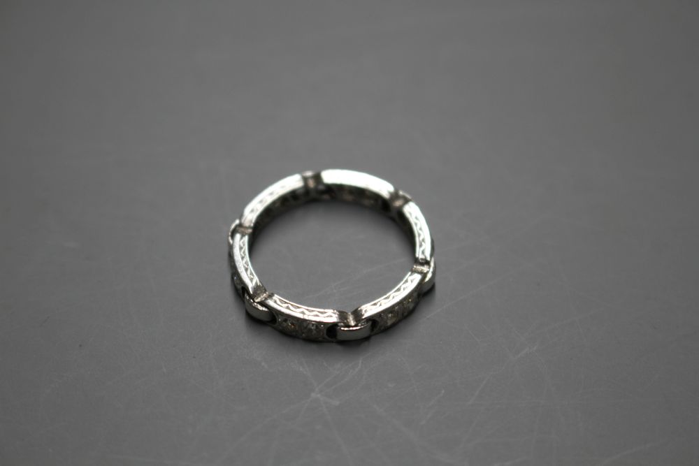 An unusual white metal (stamped Plat) and twelve stone diamond set eternity ring,